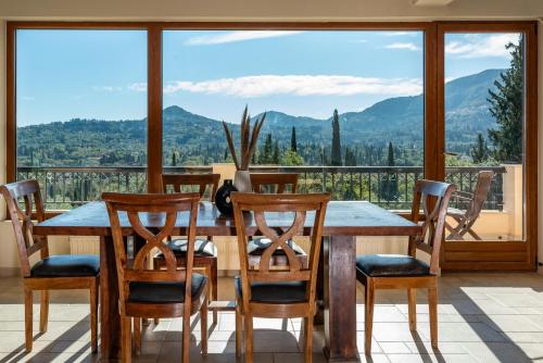 a dining room with a table and chairs and a large window at Mansion on the Hill by CorfuEscapes in Virós