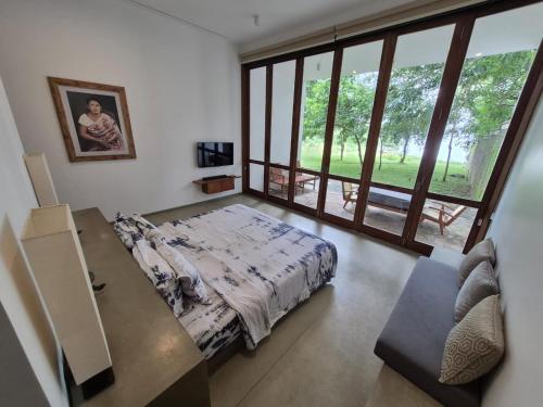 a bedroom with a bed and a large window at Arachchi Heritage in Anuradhapura