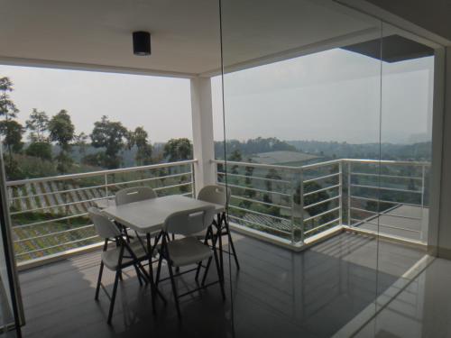 a room with a table and chairs on a balcony at Villa Rosvita Bandung in Lembang
