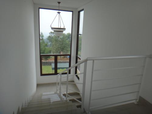 a staircase in a house with a window and a chandelier at Villa Rosvita Bandung in Lembang