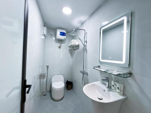 a white bathroom with a toilet and a sink at Mai Chau Sky Resort in Mai Chau
