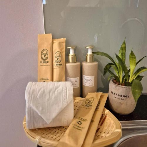 a basket with three bottles of soap and a plant at FF Homestay Evy House in Ho Chi Minh City