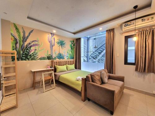ein Schlafzimmer mit einem Bett, einer Couch und einem Stuhl in der Unterkunft FF Homestay Evy House in Ho-Chi-Minh-Stadt