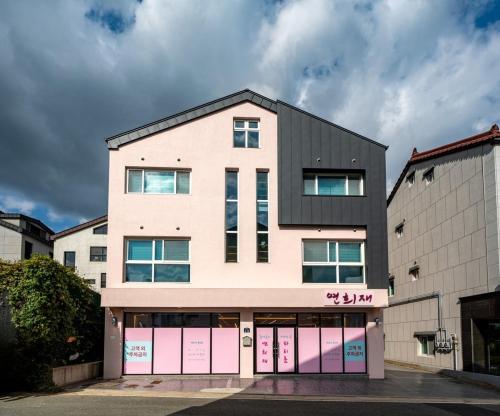 a building with pink doors and a black roof at Yeonhuijae Pool Villa Private Beomeo Branch in Yangsan