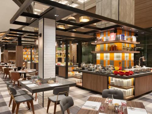 a restaurant with tables and chairs and a kitchen at JEN Singapore Tanglin by Shangri-La in Singapore