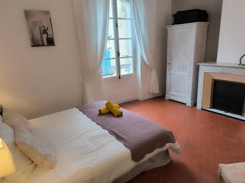 a bedroom with a teddy bear sitting on a bed at Les Chambres De Charlotte in Cucuron