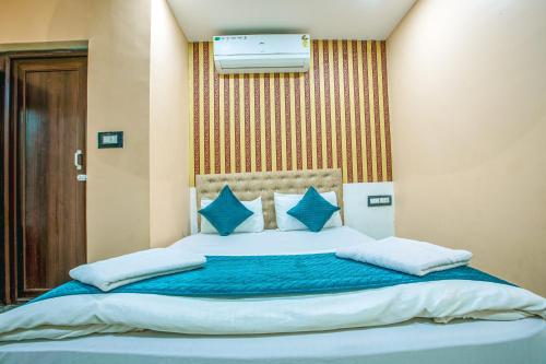 a bedroom with a large bed with blue pillows at Silver Star Residency in Bhubaneshwar