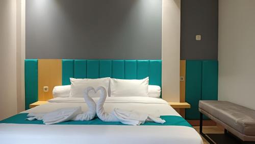 a bed with two swans made out of towels at Casaluna Bed & Breakfast By Avalon in Purwokerto