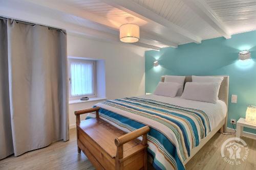 une chambre avec un lit avec un mur bleu dans l'établissement Roz vallee 2, à Perros-Guirec