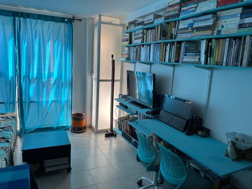 a room with a desk with a laptop and a television at Aeropuerto Pantitlán CDMX in Mexico City