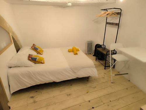 a bedroom with a bed with yellow pillows on it at Les studettes du Beffroi in Cucuron