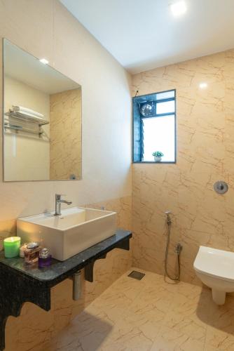 a bathroom with a sink and a toilet at Thalaiva Villa by Hillstayion in Panchgani