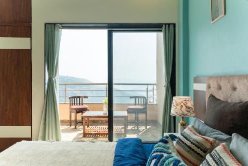 a bedroom with a bed and a view of a balcony at Thalaiva Villa by Hillstayion in Panchgani