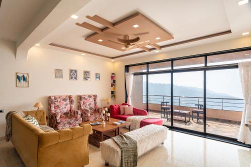 a living room with two couches and a table at Thalaiva Villa by Hillstayion in Panchgani
