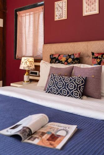 a bedroom with a bed with a magazine on it at Thalaiva Villa by Hillstayion in Panchgani