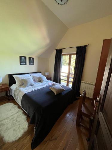 a bedroom with a large bed and a window at Vila Dragana in Žabljak