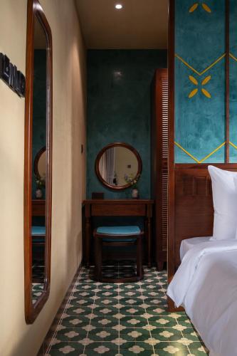 a bedroom with a bed and a desk and a mirror at The Mist Boutique DaLat Hotel in Da Lat