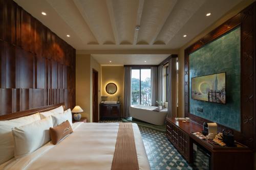 a bedroom with a large bed and a bath tub at The Mist Boutique DaLat Hotel in Da Lat