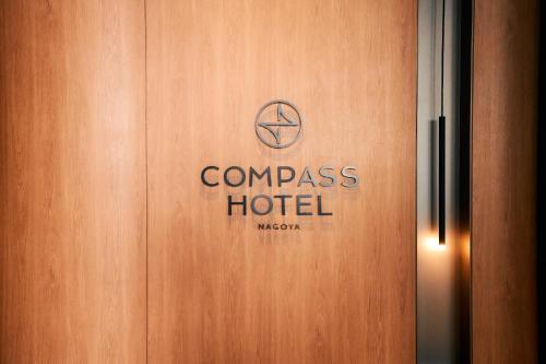 a wooden door with the words compass hotel on it at Compass Hotel Nagoya in Nagoya