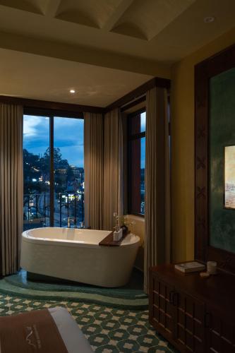 a large bathroom with a tub and a large window at The Mist Boutique DaLat Hotel in Da Lat