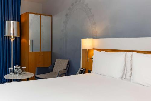a hotel room with a bed and a chair at DoubleTree by Hilton Hotel London - Tower of London in London