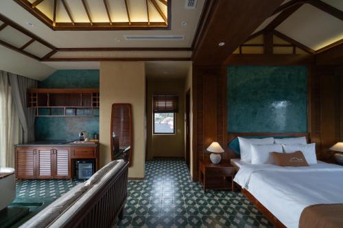 a bedroom with a large bed and a kitchen at The Mist Boutique DaLat Hotel in Da Lat