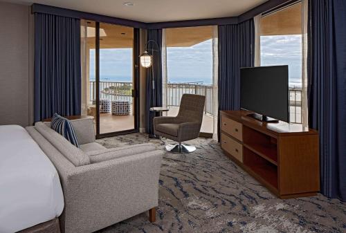 a bedroom with a bed and a television and a balcony at Hyatt Regency Mission Bay Spa and Marina in San Diego