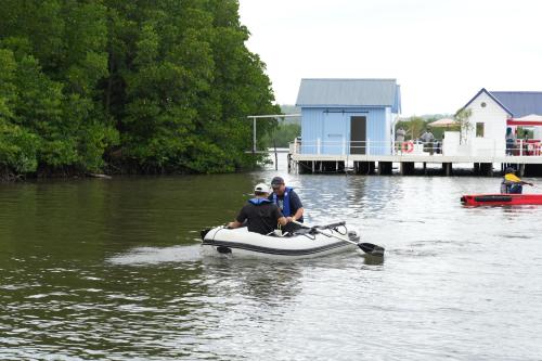 two men in a small boat in the water at Curve56 in Tuaran
