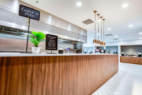 een bar in een restaurant met een bord op de toonbank bij Embassy Suites by Hilton Louisville East in Louisville