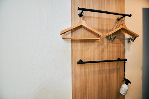 a wooden closet with hangers on a wall at Compass Hotel Nagoya in Nagoya