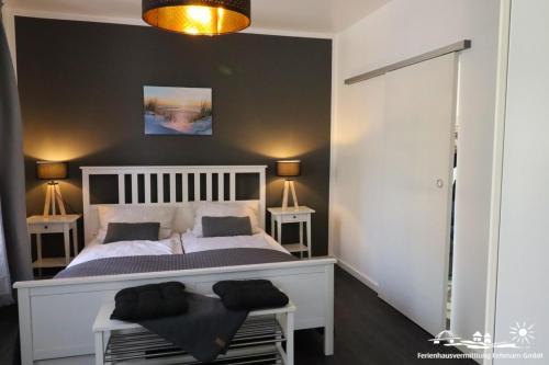Un dormitorio con una gran cama blanca con dos mesas. en 38 Weiße Villa am Schwanenteich EG links, en Burg auf Fehmarn