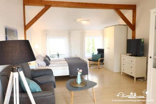 a living room with a bed and a couch at 41 Weiße Villa am Schwanenteich OG rechts in Burg auf Fehmarn