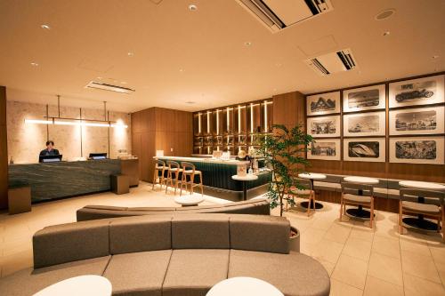 a restaurant with a bar with chairs and a counter at Compass Hotel Nagoya in Nagoya