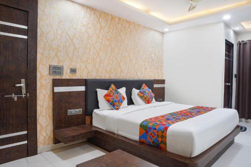 a bedroom with a bed and a wooden door at FabHotel Jalsa DLX in Bhopal