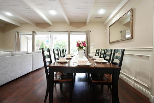 a dining room table with chairs and a vase of flowers at Destination #03 in Fullerton
