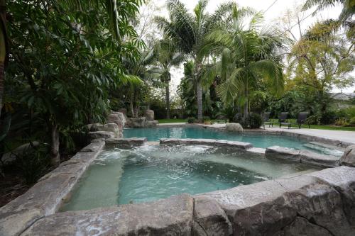 a swimming pool in a garden with a rock wall at Destination #03 in Fullerton