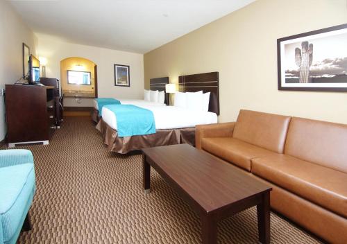 a hotel room with a bed and a couch at Americas Best Value Inn Cuero in Cuero