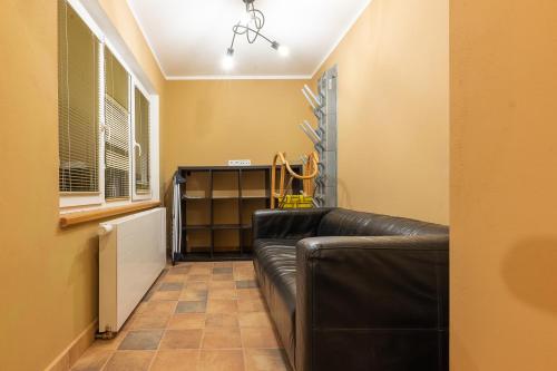 a living room with a leather couch in a room at Apartmány za Královskou mincovnou in Jáchymov