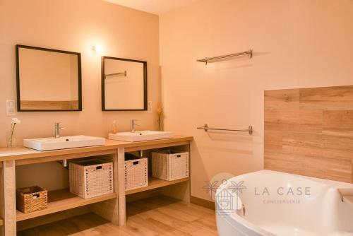 une salle de bain avec deux lavabos et une baignoire dans l'établissement Villa familiale 10min de l'océan piscine chauffée, à Saubion