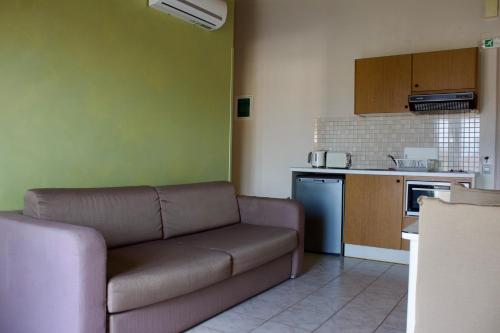 a living room with a couch and a kitchen at Notos Luxury Studios in Katelios