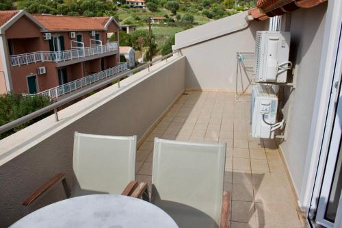 a balcony with a table and chairs on a building at Notos Luxury Studios in Katelios
