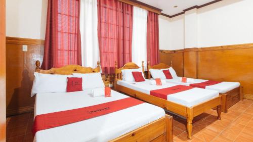 three beds in a room with red curtains at RedDoorz @ Sagada Sunrise View Homestay in Sagada