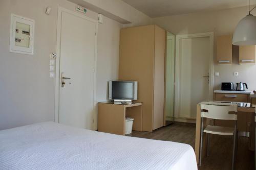 a hotel room with a bed and a television at Notos Luxury Studios in Katelios