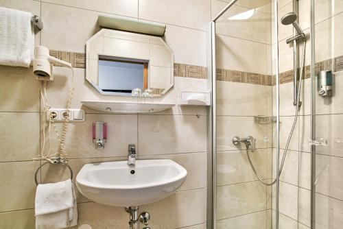 a bathroom with a sink and a glass shower at Gasthof Gigl in Neustadt an der Donau