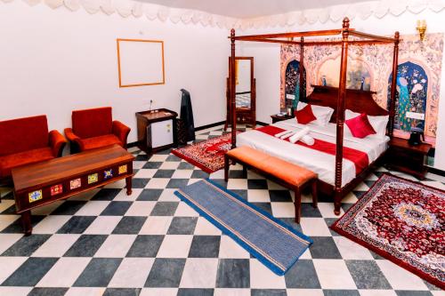 a bedroom with a bed and a couch and a chair at Marubhumi Luxury Resort in Sām