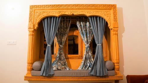 a chair with blue curtains in front of a mirror at Marubhumi Luxury Resort in Sām