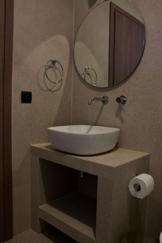 a bathroom with a white sink and a mirror at Notos Luxury Studios in Katelios