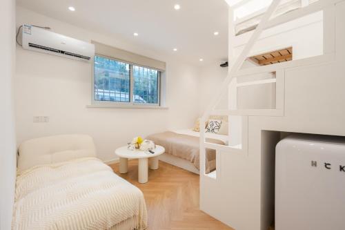 a small white room with a bed and a table at Tonight Homestay South Shanxi Road Shanghai in Shanghai