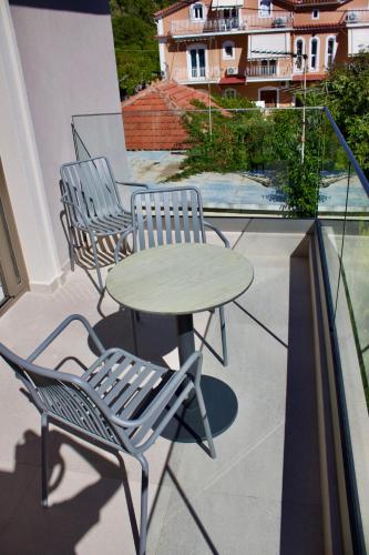 three chairs and a table on a balcony with a table at Notos Luxury Studios in Katelios