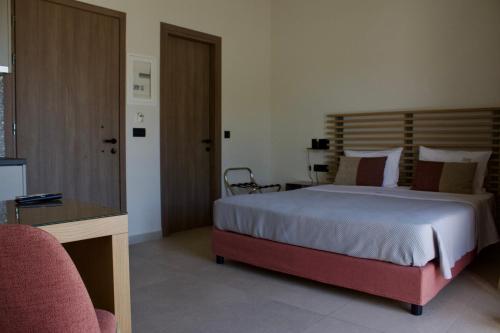 a bedroom with a bed and a desk with a chair at Notos Luxury Studios in Katelios